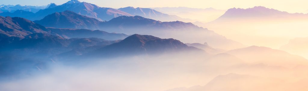 Mountain,Range,With,Visible,Silhouettes,Through,The,Morning,Colorful,Fog.