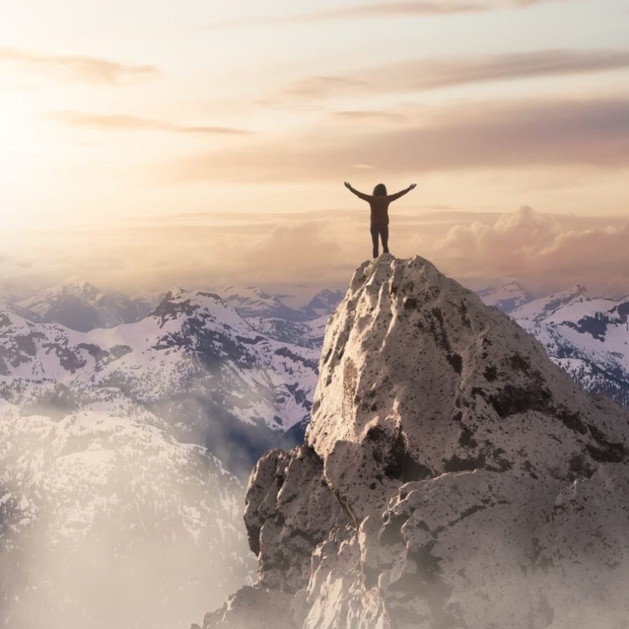 Adult,Adventurous,Woman,Standing,On,Top,Of,A,Snow,Peak.